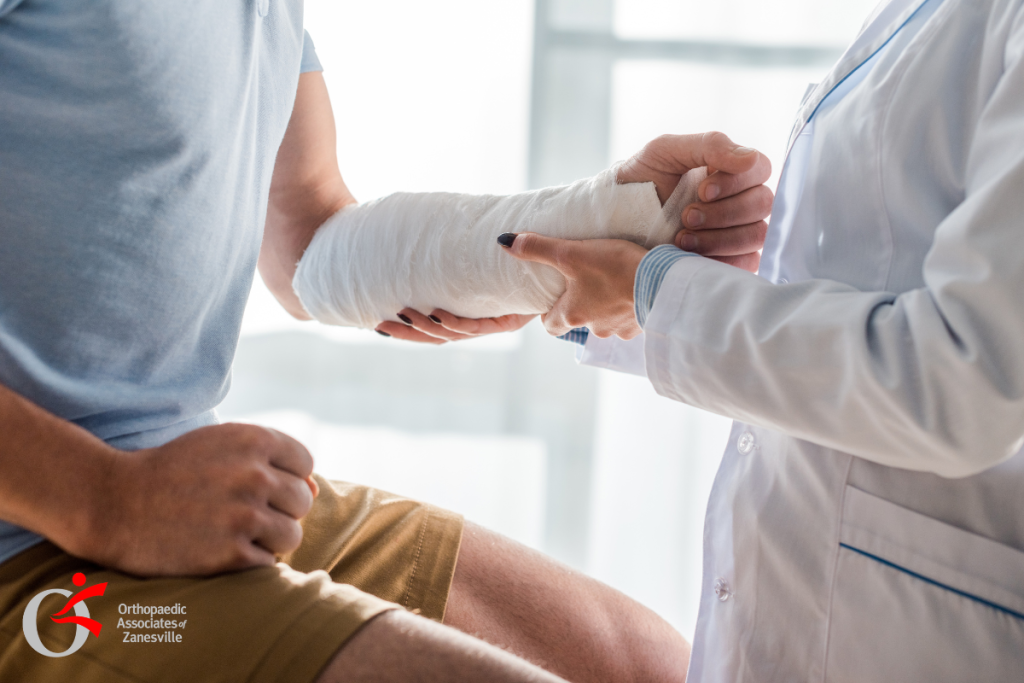 An adult man at the doctor after injury with his arm in a cast to treat his forearm fracture in Zanesville, Ohio.